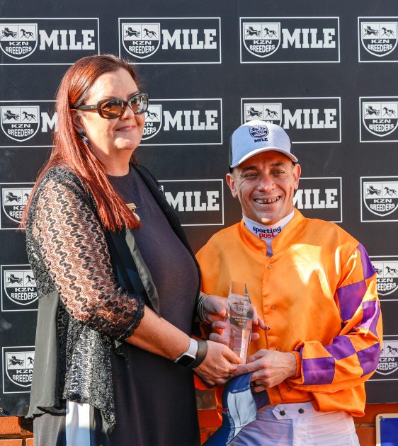Chairperson of KZN Breeders, Cathy Martin presents the trophy to Sporting Post-sponsored jockey Sean Veale 