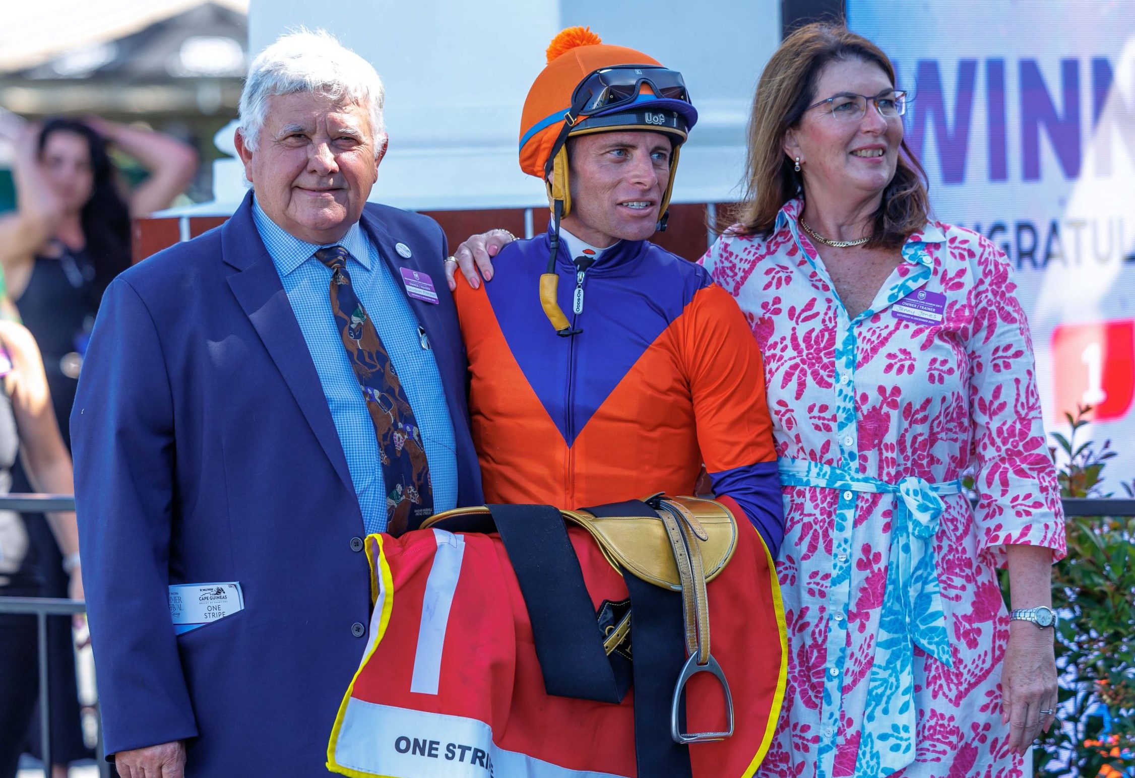 Gavin Lerena is flanked by trainer Vaughan Marshall and his partner Jenny Jones after One Stripe’s cracking win